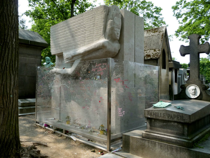 The tomb of Oscar Wilde with the protective glass barrier by Agateller, Public Domain