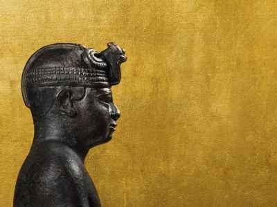 A statue of a pharaoh over a gold background