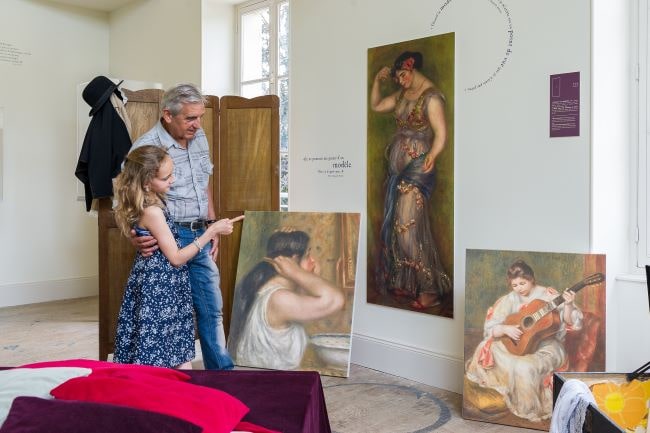 An old man and a young girl pointing at paintings