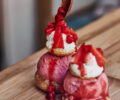Strawberry ice cream with strawberry pieces, vanilla whipped cream, topped with strawberry sauce and fresh strawberries.