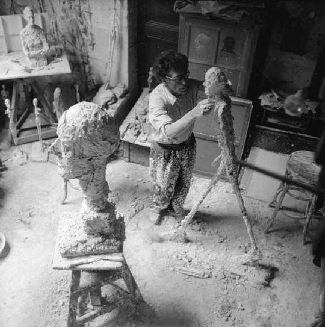 Giacometti working on the plaster sculpture for L'homme qui marche