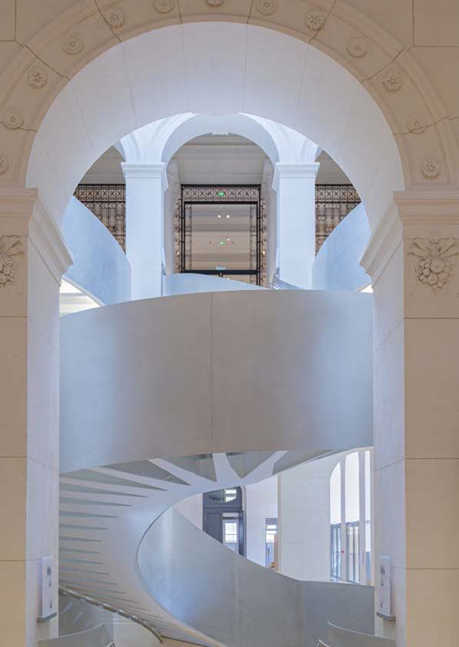 An archway to a white spiral staircase