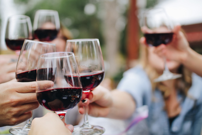 A group of people with a glass of wine