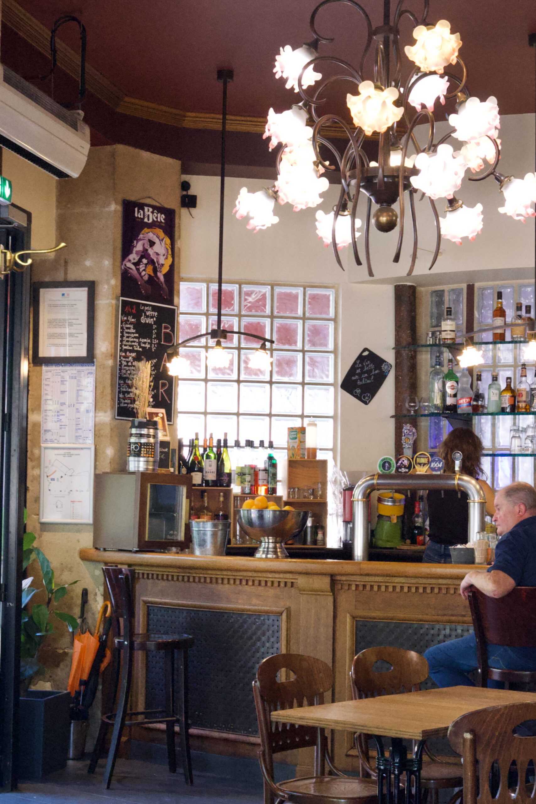 A photo of a man sat at a bar under an impressive light