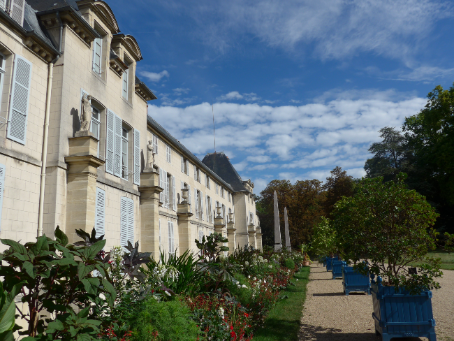 Back of the château with small trees in blue wooden planters
