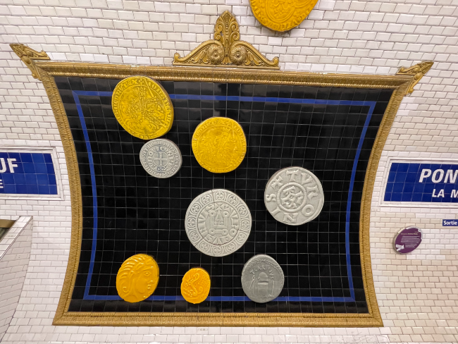 Replicas of coins on the wall of the Metro